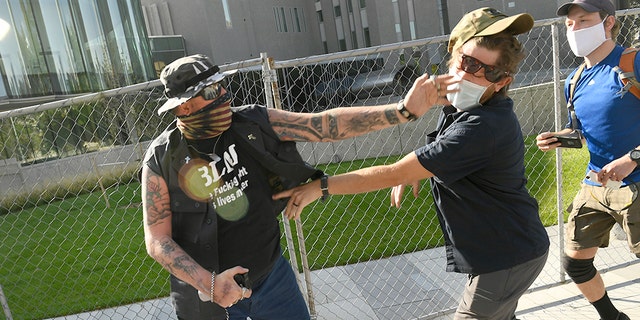 A man punches another man after a Saturday rally in Denver. The man on the left side of the photo was supporting the 