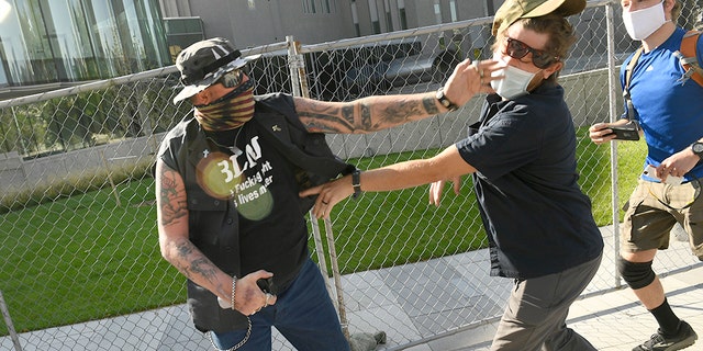 A man strikes another man after a rally in Denver last October. The man at left was supporting the "Patriot Muster" rally. He engaged with the man on the right, hit him in the face and sprayed him with mace. The man at right then shot and killed the protester at left. The man who was killed, identified as Lee Keltner, operated a hat-making business in the Denver area. (Getty Images)