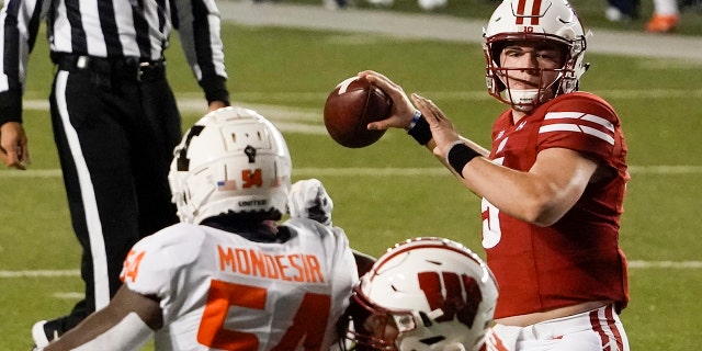 Wisconsin quarterback Graham Mertz throws a pass during the first half of an NCAA college football game against Illinois Friday, Ott. 23, 2020, in Madison, Wis. (AP Photo/Morry Gash)