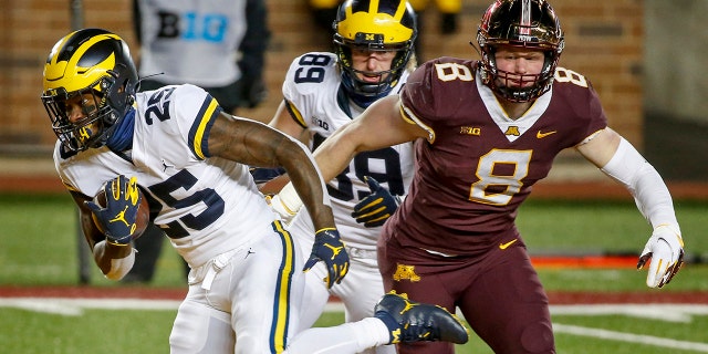 Michigan running back Hassan Haskins (25) rushes past tight end Carter Selzer (89) and Thomas Rush (8) for a touchdown in the second quarter of an NCAA college football game Saturday, Oct. 24, 2020, in Minneapolis. (AP Photo/Bruce Kluckhohn)