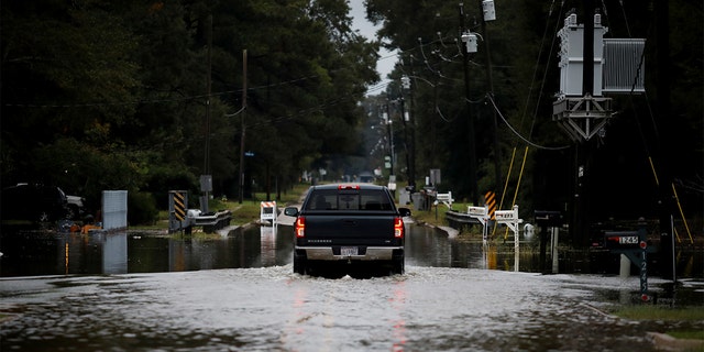 A car moves through a flooded street as Hurricane Delta approaches, in Baker, Louisiana, U.S., October 9, 2020. REUTERS/Marco Bello - RC24FJ9ZYU2E