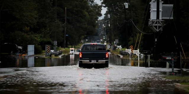 A car moves through a flooded street as Hurricane Delta approaches, in Baker, Louisiana, U.S., October 9, 2020. REUTERS/Marco Bello - RC24FJ9ZYU2E