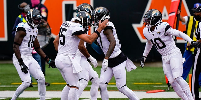 Jacksonville Jaguars wide receiver D.J. Chark (17) right celebrates a touchdown catch with quarterback Gardner Minshew (15) in the first half of an NFL football game against the Cincinnati Bengals in Cincinnati, Sunday, Oct. 4, 2020. (AP Photo/Bryan Woolston)