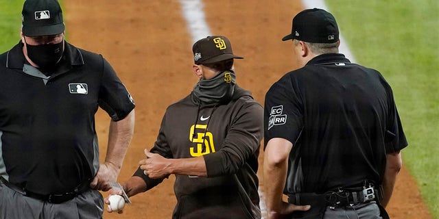 San Diego Padres manager Jayce Tingler, centro, argues with home plate umpire Lance Barrett, destra, during the sixth inning in Game 1 of a baseball NL Division Series against the Los Angeles Dodgers, martedì, Ott. 6, 2020, ad Arlington, Texas.