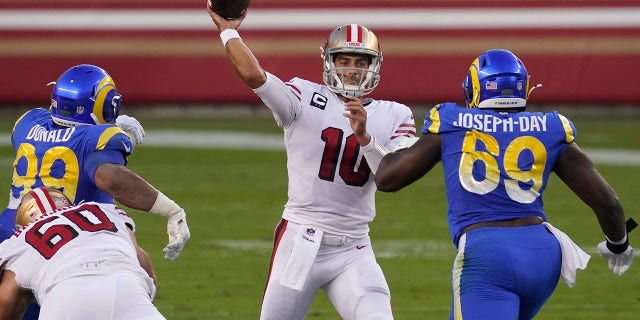 San Francisco 49ers quarterback Jimmy Garoppolo (10) passes between Los Angeles Rams defensive end Aaron Donald (99) and nose tackle Sebastian Joseph-Day (69) during the first half of an NFL football game in Santa Clara, Calif., Sunday, Oct. 18, 2020. (AP Photo/Tony Avelar)