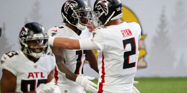 Atlanta Falcons wide receiver Julio Jones, left, celebrates with teammate Matt Ryan (2) after catching a 20-yard touchdown pass during the first half of an NFL football game against the Minnesota Vikings, Sunday, Oct. 18, 2020, in Minneapolis. (AP Photo/Bruce Kluckhohn)