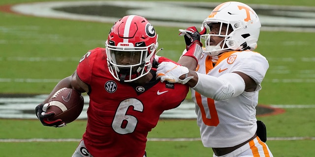 Georgia running back Kenny McIntosh (6) tries to fend off Tennessee defensive back Bryce Thompson (0) in the first half of an NCAA college football game Saturday, Oct. 10, 2020, in Athens, Ga. (AP Photo/John Bazemore)