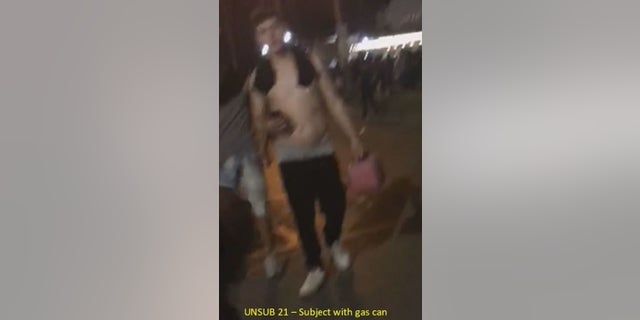 A man holds a gas can during unrest in Kenosha, Wis., federal authorities said.