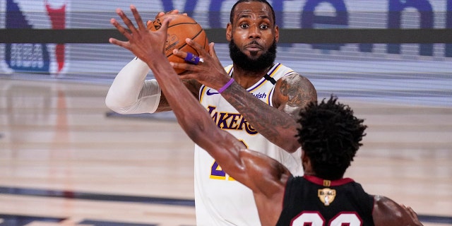 Los Angeles Lakers' LeBron James (23) looks to pass the ball against Miami Heat's Jimmy Butler (22) during the first half in Game 3 of basketball's NBA Finals, Sunday, Oct. 4, 2020, in Lake Buena Vista, Fla. (AP Photo/Mark J. Terrill)