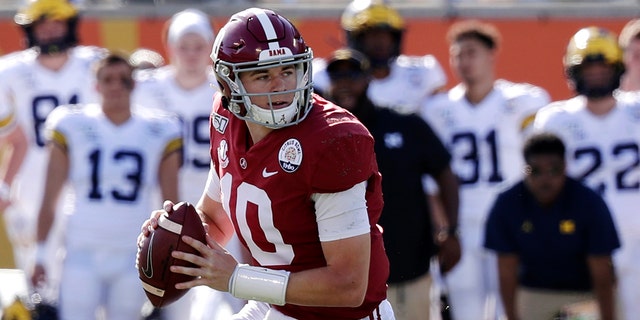 In this Jan. 1, 2020, file photo, Alabama quarterback Mac Jones (10) rolls out as he looks for a receiver during the first half of the Citrus Bowl NCAA college football game against Michigan in Orlando, Florida. (AP Photo/John Raoux, File)