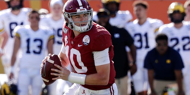 In this Jan. 1, 2020, file photo, Alabama quarterback Mac Jones (10) rolls out as he looks for a receiver during the first half of the Citrus Bowl NCAA college football game against Michigan in Orlando, Florida. (AP Photo/John Raoux, File)