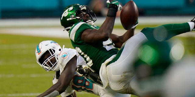 New York Jets free safety Marcus Maye (20) intercepts a pass intended for Miami Dolphins wide receiver Preston Williams (18), during the second half of an NFL football game, Sunday, Oct. 18, 2020, in Miami Gardens, Fla. (AP Photo/Lynne Sladky)