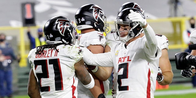 Atlanta Falcons' Todd Gurley (21) celebrates a touchdown run with quarterback Matt Ryan (2) during the second half of an NFL football game against the Green Bay Packers, Monday, Oct. 5, 2020, in Green Bay, Wis. (AP Photo/Mike Roemer)