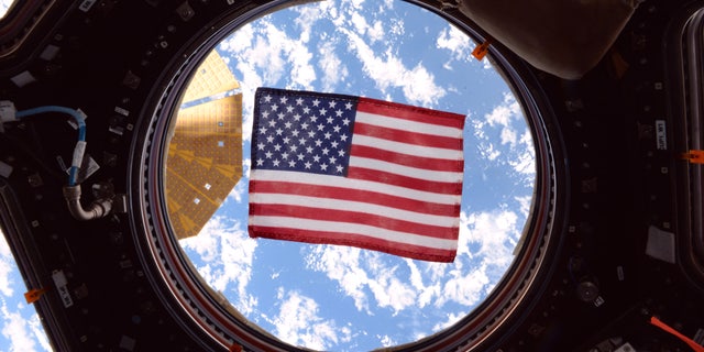 An American flag in one of the windows of the International Space Station's cupola