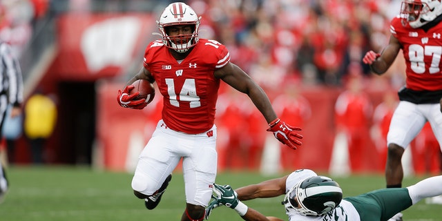 FILE - In this Oct. 12, 2019, file photo, Wisconsin running back Nakia Watson (14) runs past Michigan State safety Xavier Henderson (3) during the first half of an NCAA college football game, in Madison, Wis. (AP Photo/Andy Manis, File)