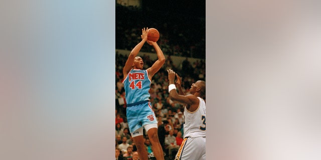Derrick Coleman of the New Jersey Nets (44) takes a shot over the top of Tyrone Hill of the Golden State Warriors (32) during first quarter action at the Oakland Coliseum, 十一月. 24, 1990. (AP Photo/Alan Greth)
