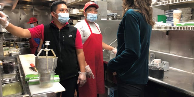 South Dakota Gov. Kristi Noem speaks with the kitchen staff during a stop at the famed Red Arrow Diner in Manchester, New Hampshire on Oct. 15, 2020
