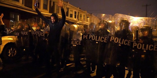 Sharif Proctor lifts his hands up in front of the police line during a protest in response to the police shooting of Walter Wallace Jr., Monday, Oct. 26, 2020, in Philadelphia. Police officers fatally shot the 27-year-old Black man during a confrontation Monday afternoon in West Philadelphia that quickly raised tensions in the neighborhood. (Jessica Griffin/The Philadelphia Inquirer via AP)