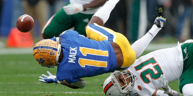 FILE - In this Saturday, Oct. 26, 2019, file photo, Pittsburgh wide receiver Taysir Mack (11) fumbles the ball after getting hit by Miami's Bubba Bolden (21) during the first half of an NCAA college football game, in Pittsburgh. (AP Photo/Keith Srakocic, File)