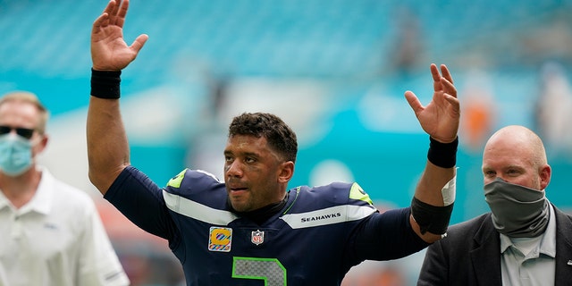 Seattle Seahawks quarterback Russell Wilson (3) raises his hands as fans cheer at the end of an NFL football game, Sunday, Oct. 4, 2020 in Miami Gardens, Fla. The Seahawks defeated the Dolphins 31-23.(AP Photo/Wilfredo Lee)