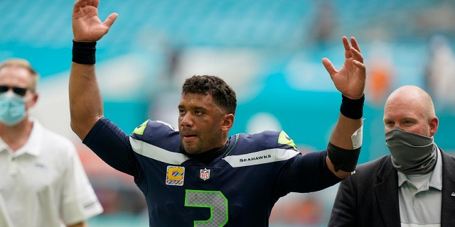 Seattle Seahawks quarterback Russell Wilson (3) raises his hands as fans cheer at the end of an NFL football game, Sunday, Oct. 4, 2020 in Miami Gardens, Fla. The Seahawks defeated the Dolphins 31-23.(AP Photo/Wilfredo Lee)