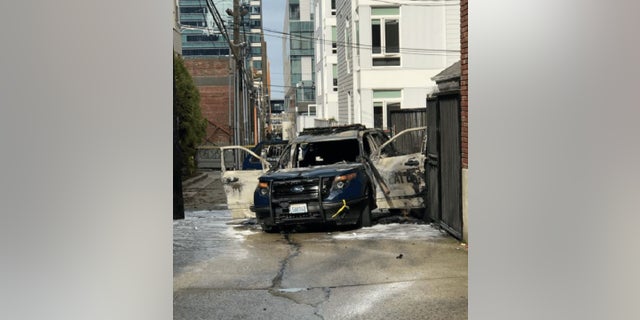 A man allegedly threw a flaming piece of lumber into a Seattle police vehicle Thursday, injuring one officer.