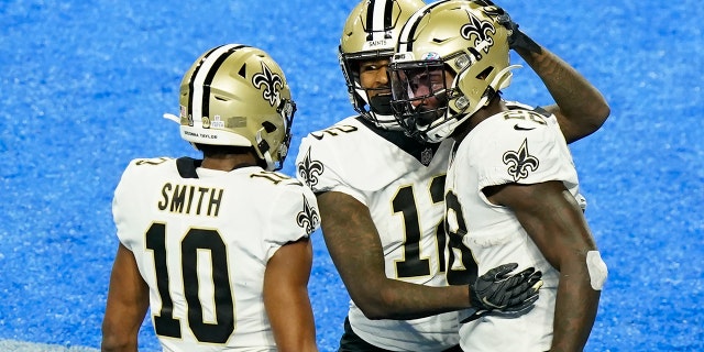 New Orleans Saints running back Latavius Murray, right, is congratulated by teammates wide receivers Marquez Callaway (12) and Tre'Quan Smith (10) after scoring on a 6-yard run during the second half of an NFL football game against the Detroit Lions, Sunday, Oct. 4, 2020, in Detroit. (AP Photo/Carlos Osorio)