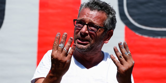 New York artist Scott LoBaido speaks after he unveils a 'Patriotic Lawn T' in support 2016 Republican presidential nominee Donald Trump in the area of Castleton Corners on Staten Island, New York on August 9, 2016. LoBaido's 12-foot-high "T" was destroyed fire set by an unidentified arsonist on Aug. 7. Lobaido created a brand new statue that stands in the yard belonging to Trump supporter Sam Pirozzolo. (KENA BETANCUR/AFP via Getty Images)