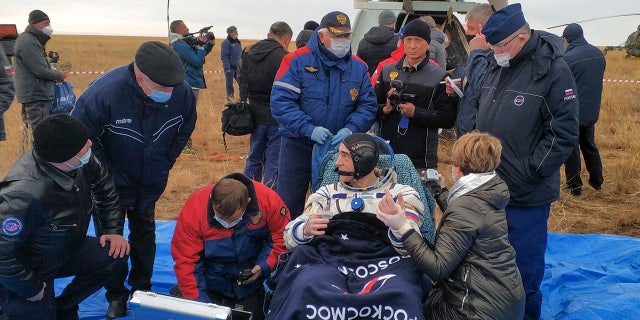 In this photo released by Rosaviatsiya, Roscosmos' cosmonaut Anatoly Ivanishin sits in a chair shortly after the landing near town of Dzhezkazgan, Kazakhstan, Thursday, Oct. 22, 2020.