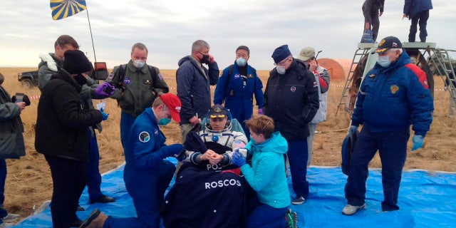 In this photo released by Roscosmos Space Agency, NASA astronaut Chris Cassidy sits in a chair shortly after landing near town of Dzhezkazgan, Kazakhstan, Thursday, Oct. 22, 2020.