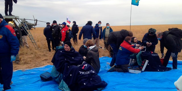 In this photo released by Roscosmos Space Agency, Roscosmos' cosmonauts Anatoly Ivanishin, left, and Ivan Vagner sit in fchairs shortly after the landing near town of Dzhezkazgan, Kazakhstan, Thursday, Oct. 22, 2020.