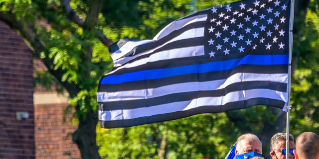 Pro-police protesters carry a Blue Lives Matter flag at a protest.
