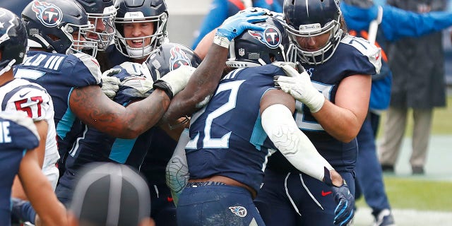 Tennessee Titans running back Derrick Henry (22) is mobbed by teammates after Henry scored the winning touchdown against the Houston Texans in overtime of an NFL football game Sunday, Oct. 18, 2020, in Nashville, Tenn. The Titans won 42-36. (AP Photo/Wade Payne)