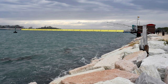 Yellow barriers are raised during high water in Venice, northern Italy, Saturday, Oct. 3, 2020.