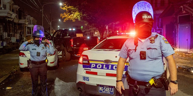 Police officers guard a pickup truck loaded with looted merchandise following protests in 2020. REUTERS/David 'Dee' Delgado