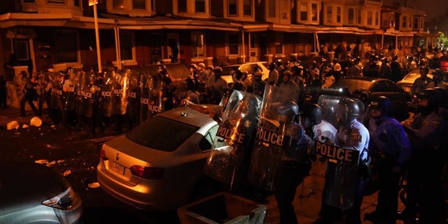 Police officers move in formation during a protest in response to the police shooting of Walter Wallace Jr., Monday, Oct. 26, 2020, in Philadelphia. (Jessica Griffin/The Philadelphia Inquirer via AP)