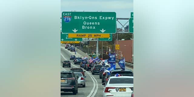 A caravan of Trump supporters driving through NYC, prominently displaying Trump 2020 flags. 