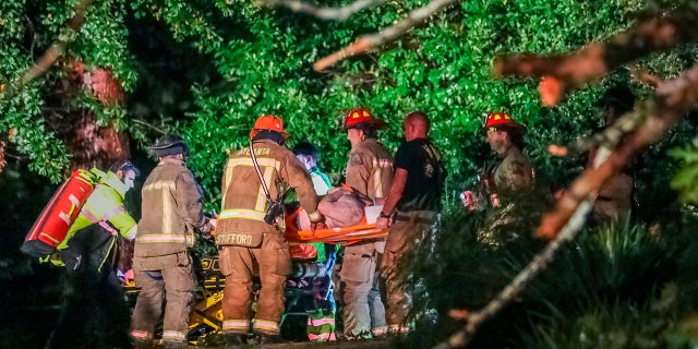 Atlanta firefighters transport a man they freed who was trapped in his third-floor bedroom after a tree came crashing down on a home on Brookview Drive in Atlanta, as Tropical Storm Zeta sped across the Southeast Thursday, Oct. 29, 2020.