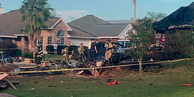 Firefighters worked to extiguish the flames from the crash after a home and several cars were engulfed. (Greg Crippen via AP)