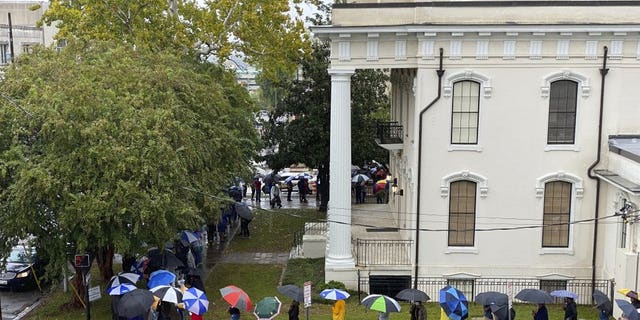People wait in the rain to vote in Montgomery, Ala., on Saturday, Oct. 24, 2020. Alabama Secretary of State John Merrill said a record number of absentee ballots have already been cast this year in the election. Some counties allowed Saturday voting for the first time. (AP Photo/Kim Chandler)