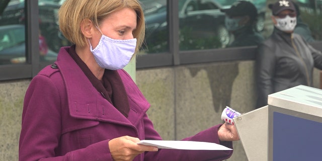 Amy Kennedy drops off her mail-in ballot in Atlantic City, N.J.