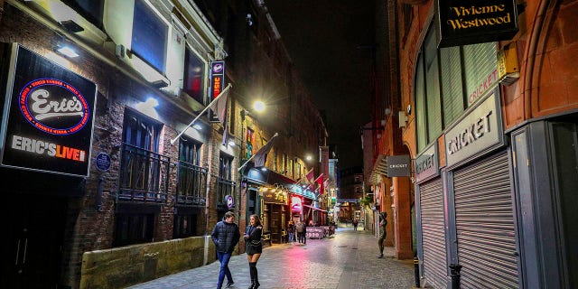 An empty looking Mathew Street in Liverpool, England, as drinkers stay at home and follow coronavirus restrictions, Friday, Oct. 9, 2020, ahead of a new three-tiered system of restrictions that Prime Minister Boris Johnson will outline on Monday that is expected to cause pubs and restaurants to shut across the north of England. (Peter Byrne/PA via AP)