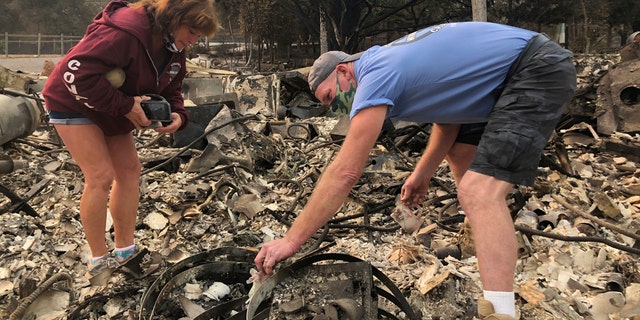 Kevin Conant and his wife, Nikki, sift through the debris of their burnt home and business "Conants Wine Barrel Creations," after the Glass/Shady fire completely engulfed it, Wednesday, Sept. 30, 2020, in Santa Rosa, Calif.