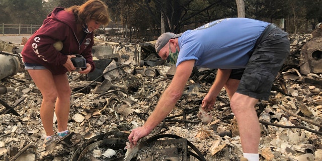 Kevin Conant and his wife, Nikki, sift through the debris of their burnt home and business "Conants Wine Barrel Creations," after the Glass/Shady fire completely engulfed it, Wednesday, Sept. 30, 2020, in Santa Rosa, Calif.