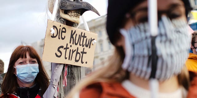 A woman holds a poster reading:'The culture dies' as she attends a protest of people working in the entertainment and event industry against the German government's economic policies to combat the spread of the coronavirus and COVID-19 disease and demand more support for their business, in Berlin, Germany, on Wednesday. (Photo/Markus Schreiber)