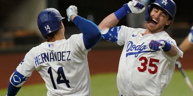 Los Angeles Dodgers' Cody Bellinger, right, celebrates his home run with Enrique Hernandez against the Atlanta Braves during the seventh inning in Game 7 of a baseball National League Championship Series Sunday, Oct. 18, 2020, in Arlington, Texas