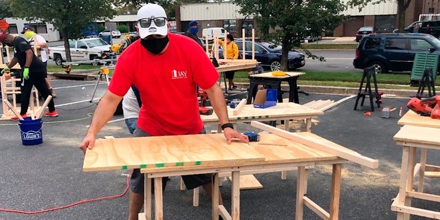 In this photo provided by Jessica Berrellez, her husband, Al Berrellez, builds a desk in Gaithersburg, Md., on Friday, Sept. 25, 2020. (Jessica Berrellez via AP
