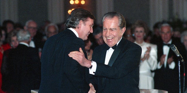 In this March 11, 1989, photo Donald Trump shakes hands with former President Richard Nixon at a tribute gala to Nellie Connally at the Westin Galleria ballroom in Houston, Texas.