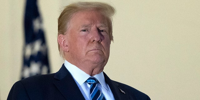 Former President Donald Trump stands on the Blue Room Balcony upon returning to the White House Monday, Oct. 5, 2020, in Washington, after leaving Walter Reed National Military Medical Center, in Bethesda, Md. Trump announced he tested positive for COVID-19 on Oct. 2. (AP Photo/Alex Brandon)