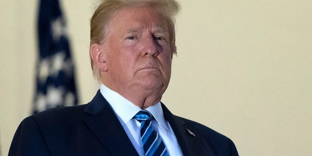 Former President Trump stands on the Blue Room Balcony upon returning to the White House Monday, Oct. 5, 2020, in Washington, after leaving Walter Reed National Military Medical Center, in Bethesda, Maryland. Trump announced he tested positive for COVID-19 on Oct. 2. 